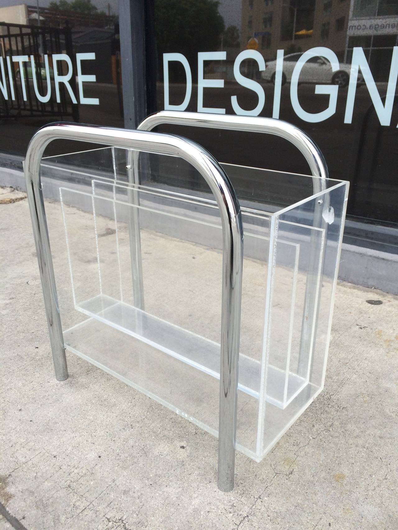 Beautiful and rare magazine holder designed and manufactured by Charles Hollis Jones in the 1970s.

The piece is executed in Lucite having a tubular chromed frame having three compartments to store books or magazines.

The piece is in very good