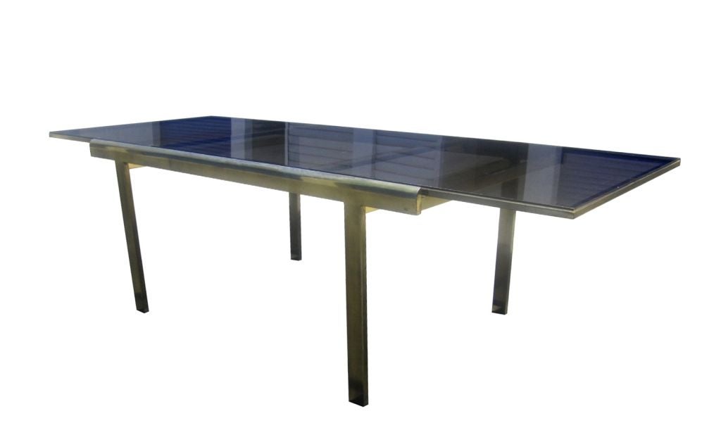 Beautiful Mastercraft dining table in Brass and smoked glass. This beautiful table is very versatile and with great lines. The expandable feature is for large parties and special occasions. The stunning brass frame is very heavy and sturdy while the