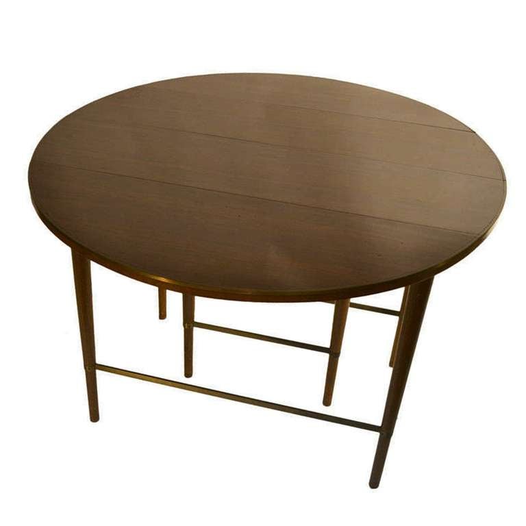Designed by Paul McCobb for the Connoisseur Collection by Sack and Sons, Brookline, MA, this beautifully made dining table was constructed of mahogany with brass band and stretchers accent. It features two drop leaves and brass stretchers.

The