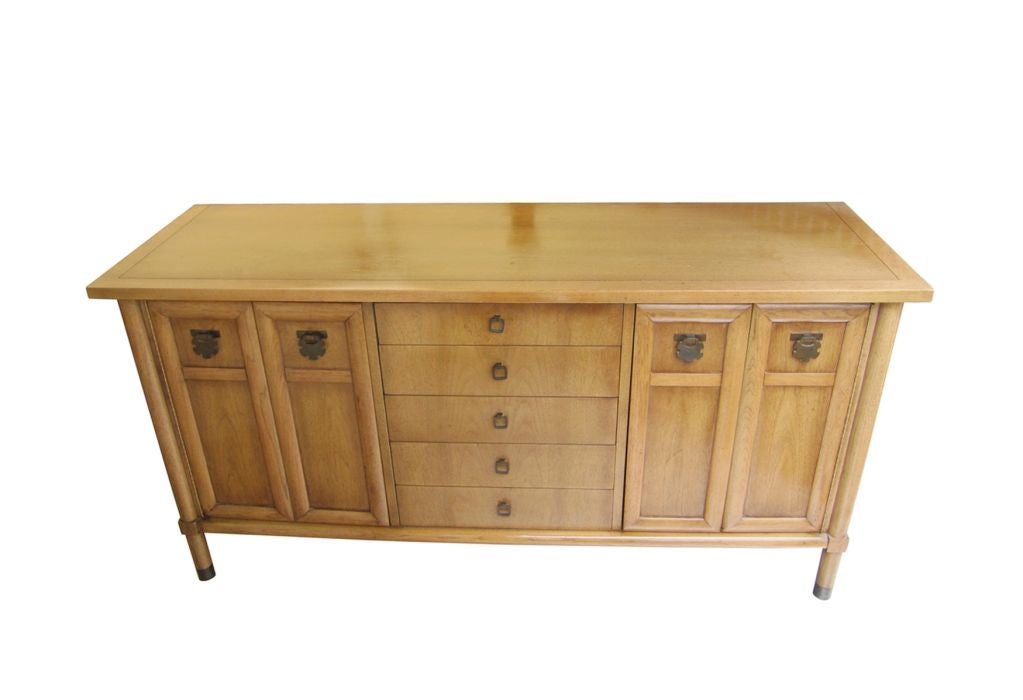 USA
1960's

The sideboard is in excellent refinished condition, finished in the original brown color with a very nice original brass accents on the drawers and legs. There is tons of storage space and the sideboard has 4 drawers in the middle and