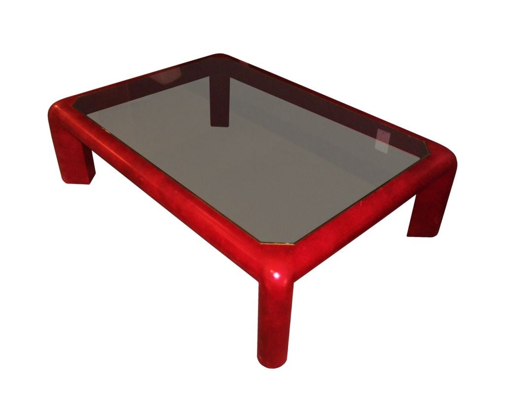 Coffee table covered in red leather with inset smoked glass top designed by Karl Springer signed and dated 1983.
This fantastic table displays wonderful architectural lines, the red leather is a color you rarely see in Karl Springer pieces which