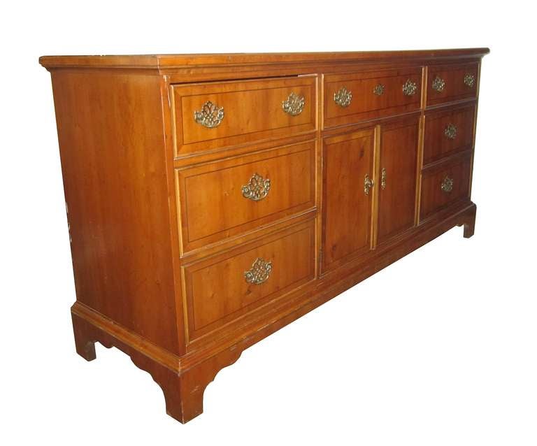 Decorative and functional 9 drawer dresser by American of Martinsville from the 1970's. The storage unit has 3 drawers on each side and 2 open drawers behind two central doors and on in the upper middle. The front facade of each drawer and trimming