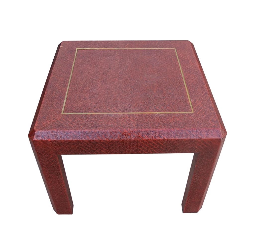 Beautiful Vintage table covered in a red colored raffia with a brass inlay detail. The edge of the table top and legs have a beveled detail adding a wonderful architectural flair. The table is very solid and sturdy and the deep red color is just