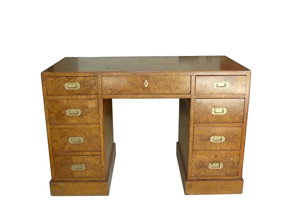 Dazzling one-of-a-kind 1960's Italian made Burl wood desk on a plinth base in the campaign style. The irregular ring pattern of burl wood is highly prized by artists and is usually used in small sculptures.  It is rarely seen in furniture due to the