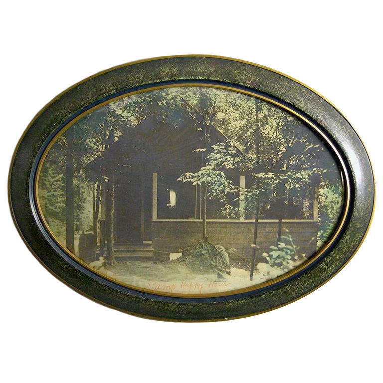 A hand colored vintage silver print image in an oval frame of convex glass.