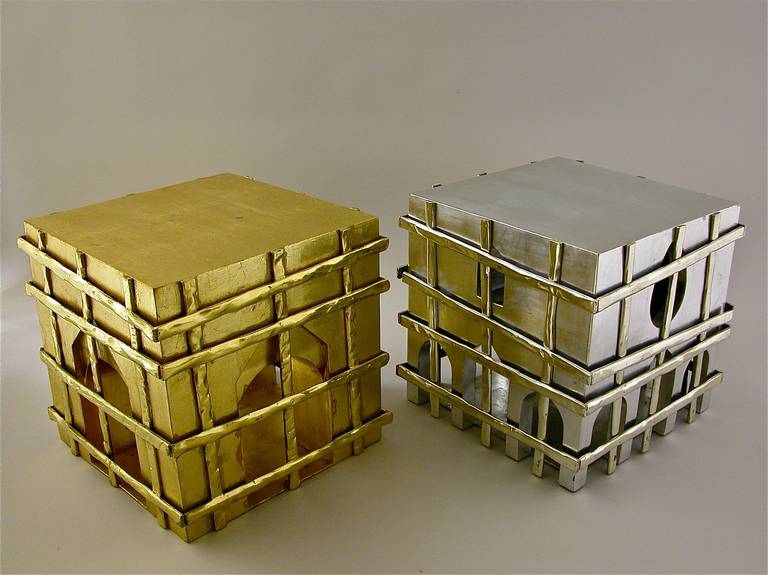 An unusual pair of architectural side tables in cubic form, gilded in metal leaf of silver and gold.