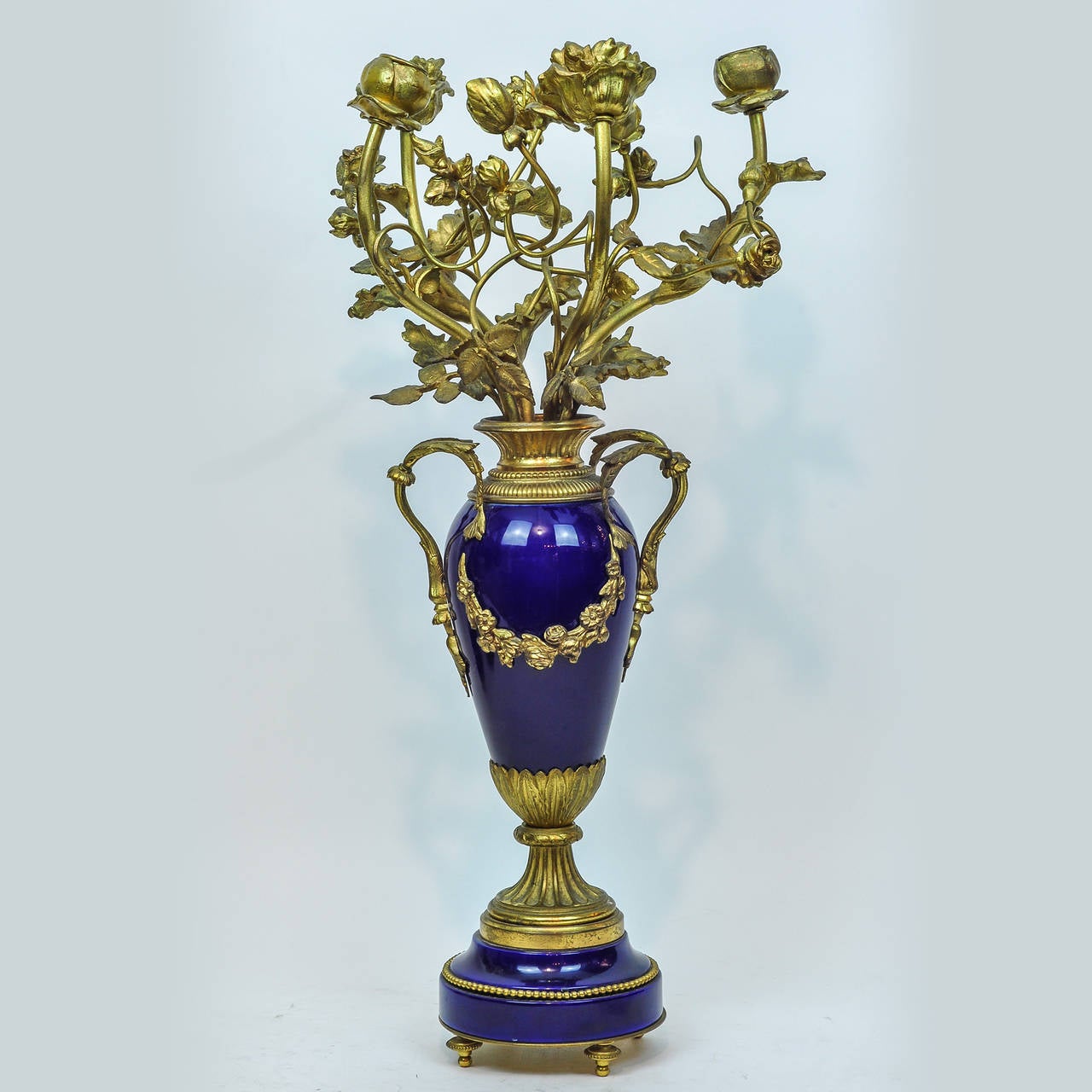 A Louis XVI Style Three Piece Cobalt blue Porcelain and Bronze Clock Garniture Set
Clock: H 22-1/2