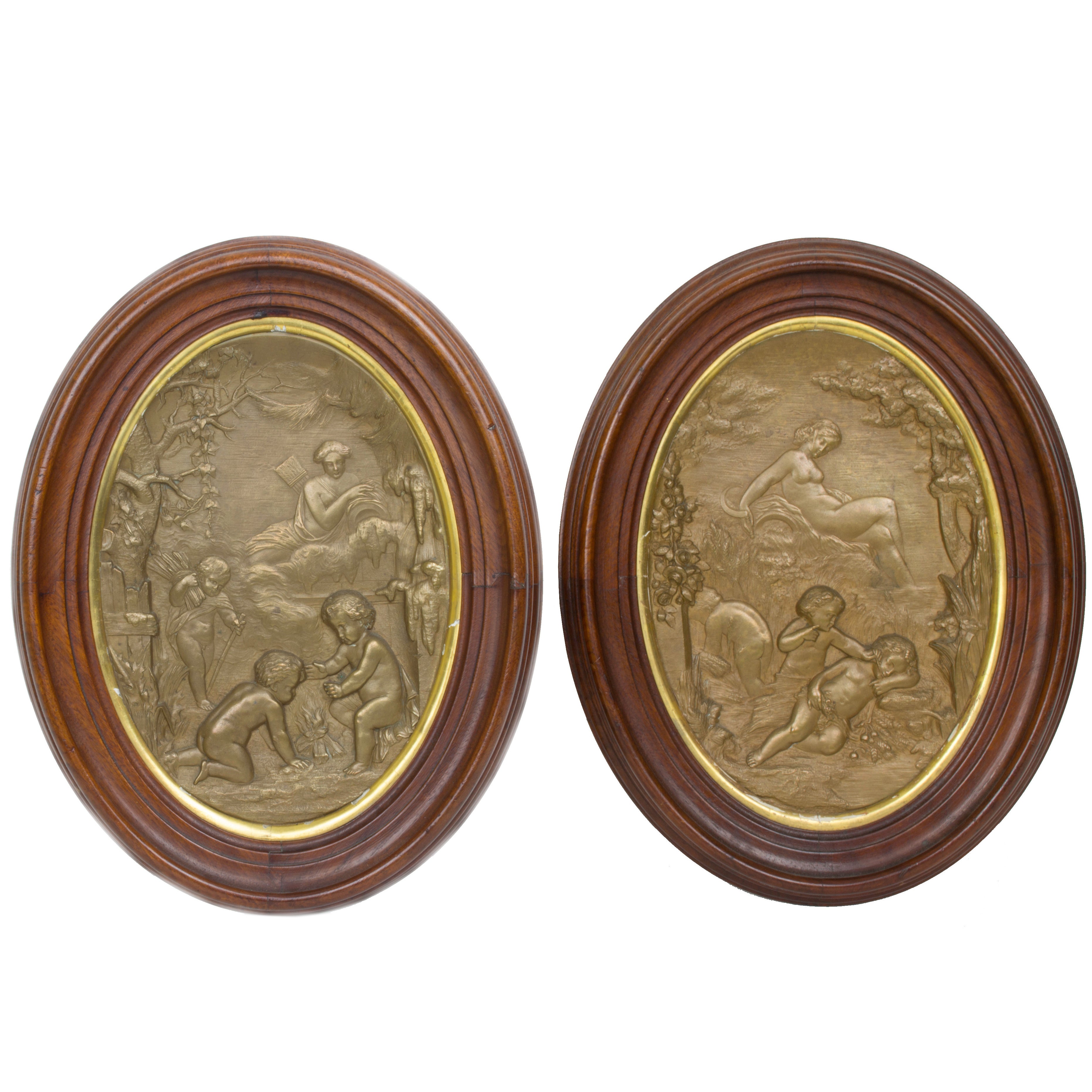 Pair of Oval Patinated Metal Wall Plaques with Cherub Decorations For Sale