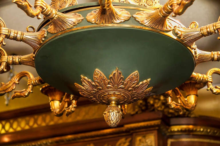 Matched pair of French Empire style two-tone patinated and gilt bronze twelve-light chandeliers.