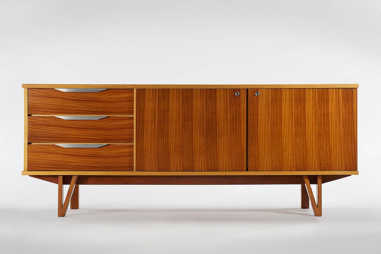 Credenza by René Jean Caillette in frêne (ash) and mahogany with aluminum handles. 
Designed in 1957 and manufactured by S.A.D.E.A.

ABOUT THE DESIGNER: René-Jean Caillette (1919–2004), was the son of a woodworker. He always intended to follow