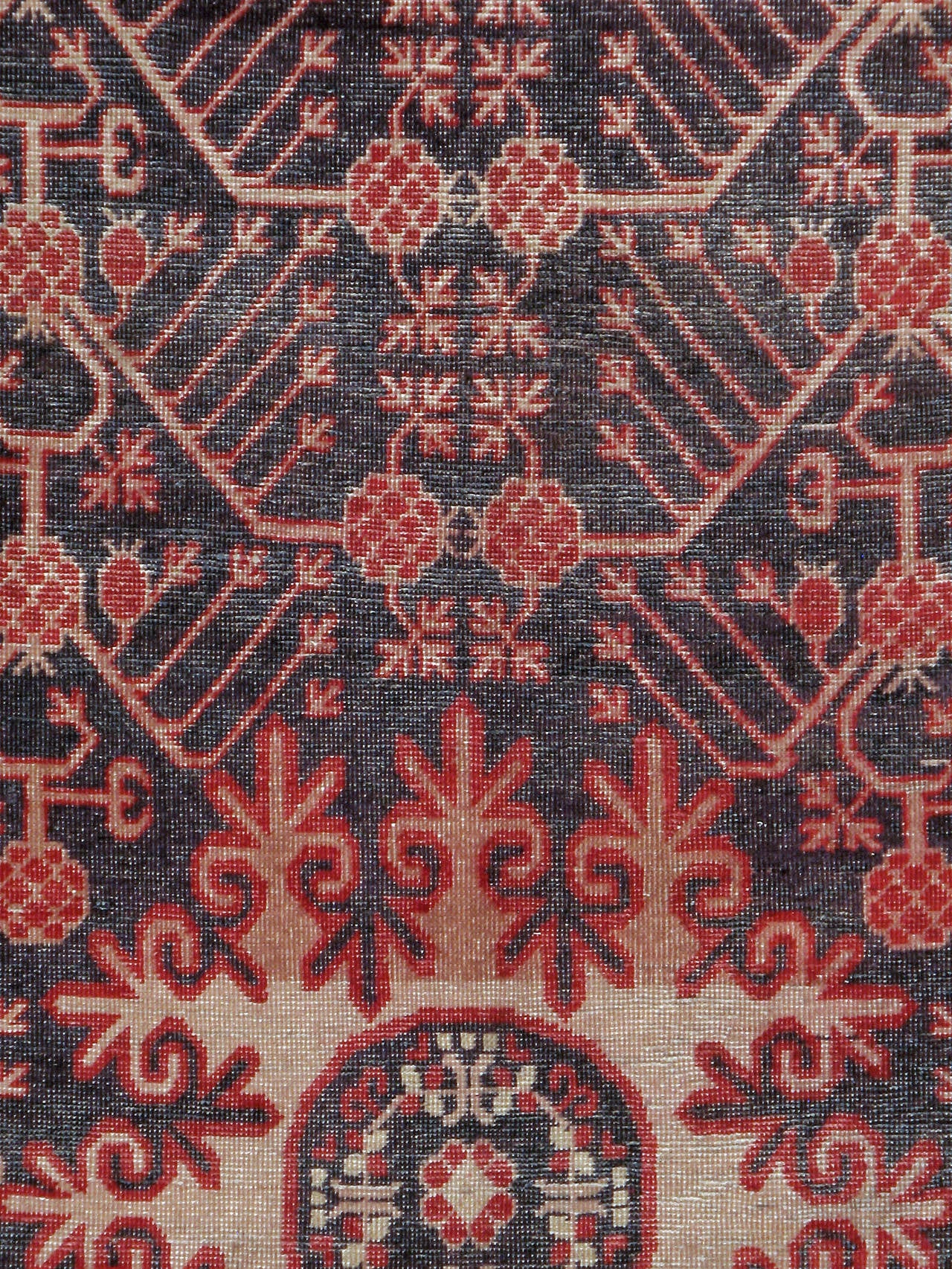 An antique East Turkestan Khotan carpet from the second quarter of the 20th century. A traditional pomegranate-vase design wraps around an unusual cloud medallion motif.

Measures: 5' 1