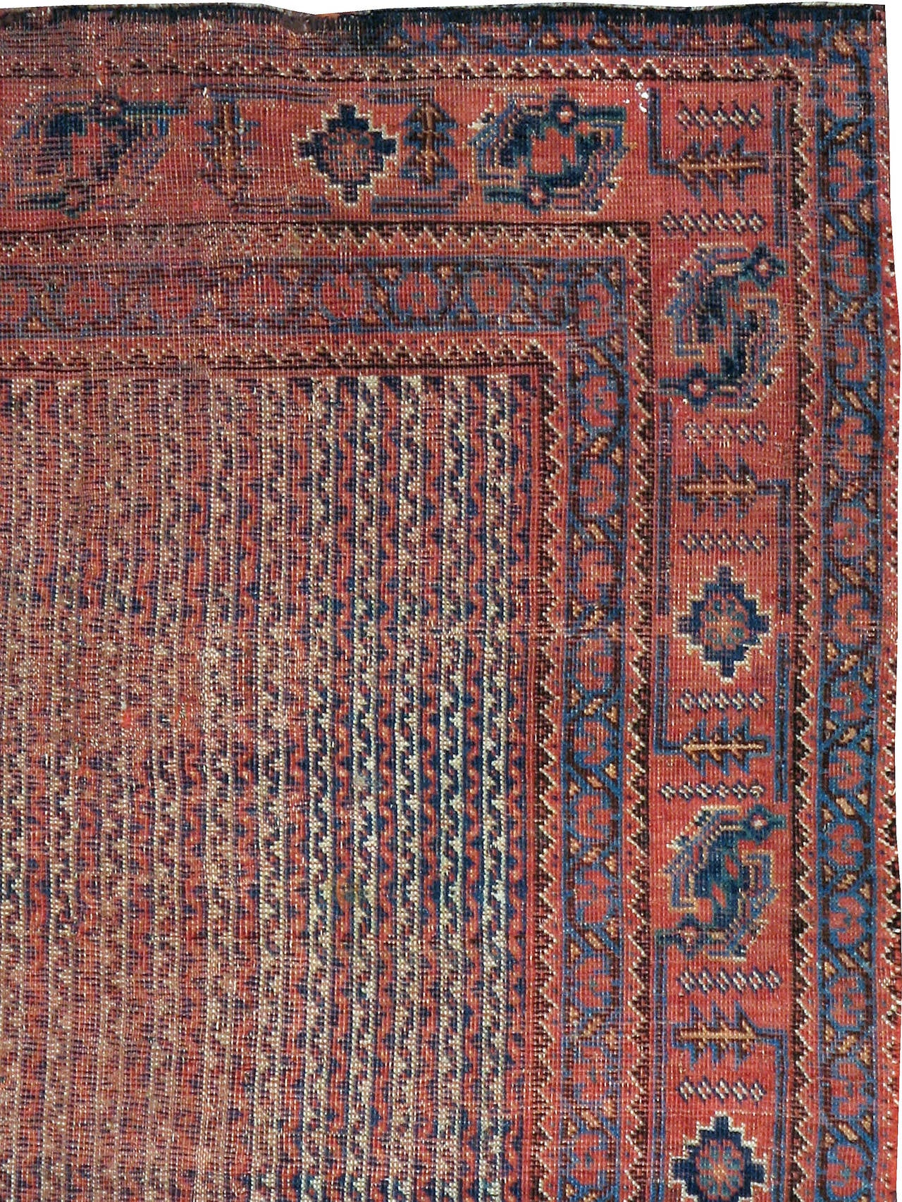 A weathered and distressed antique Persian Afshar carpet from the turn of the 20th century.