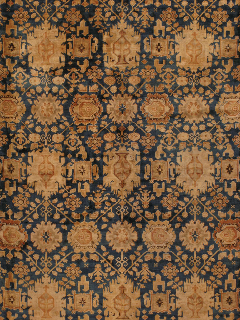 An early, first quarter 20th century Indian Agra carpet with an allover pattern made up of serrated lotus flower motifs.  Each lotus flower is connected by a diamond lattice and symbolizes immortality.  This pattern is called 'Mina Khani' in Persian