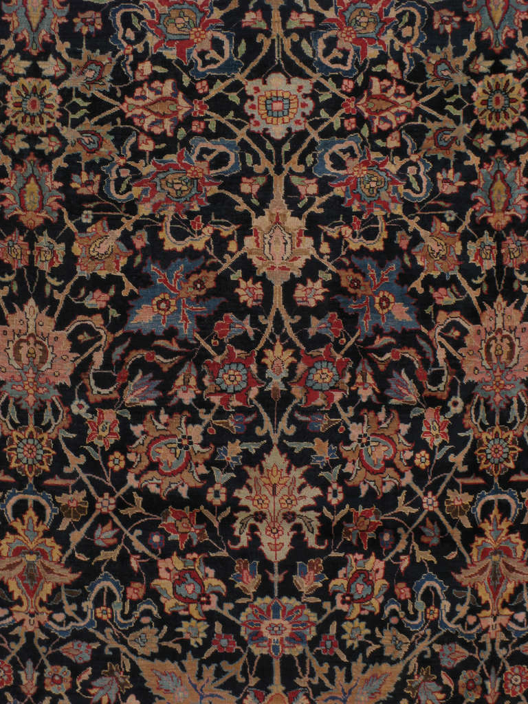 An early, second quarter 20th century Persian Tabriz carpet illustrating Shah Abbasi floral patterns and panache floret sprouts.  The flamboyant field of blooms is connected by a herati design of lozenge like intricate vines.  The field is guarded
