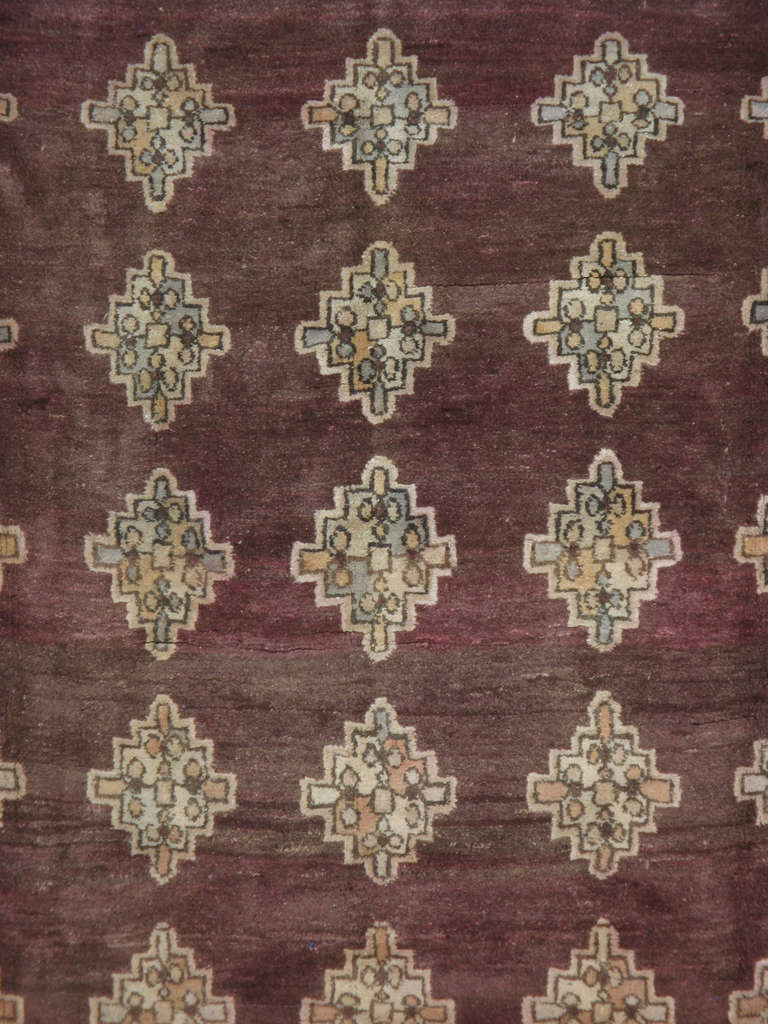 Un Samarkand Turkestan du début du 20ème siècle.  Un motif de diamants flottant sur le champ aubergine de ce tapis Samarkand ancien.