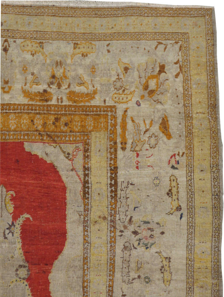 A Tabriz Hagi Jalili rug, a singular flower set on an crimson red field, accents of yellow, blue and orange.