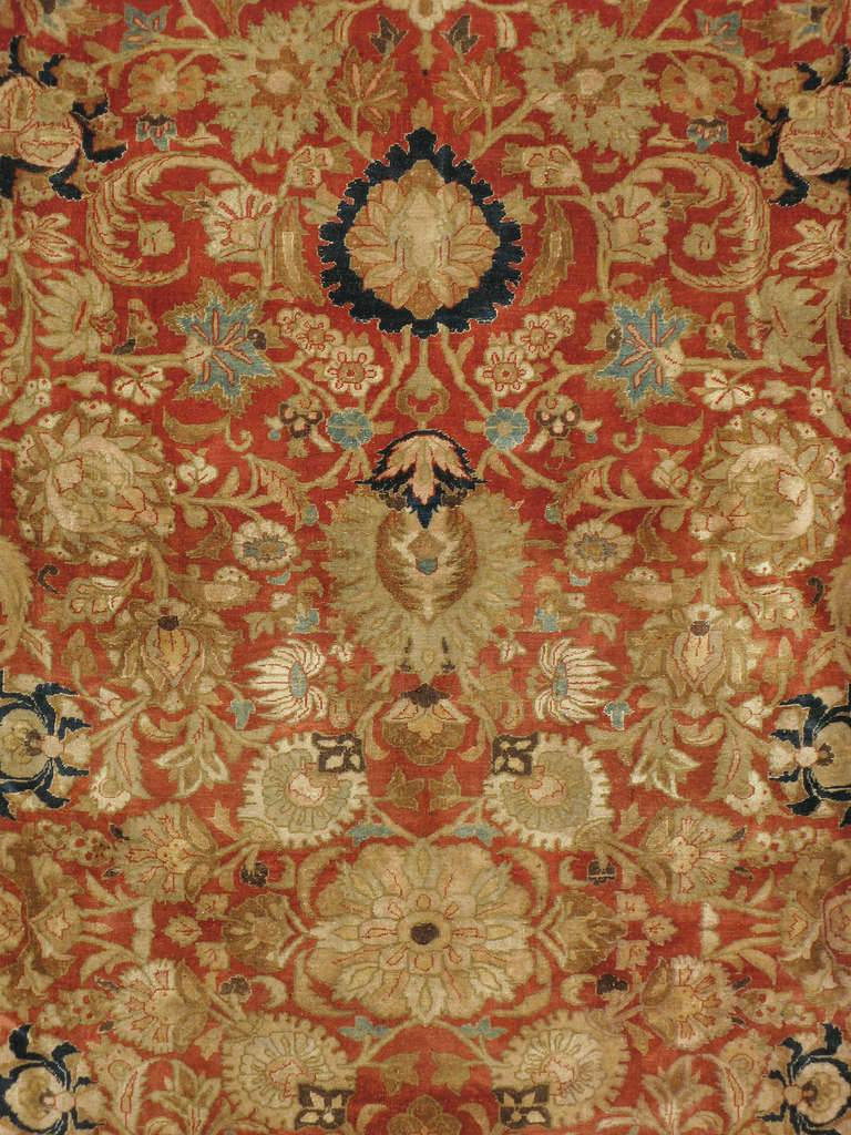 Un tappeto Tabriz persiano del primo quarto del XX secolo.  Il motivo Shah Abbasi è composto da tonalità blu navy e giallo oro su uno sfondo rosso ruggine.