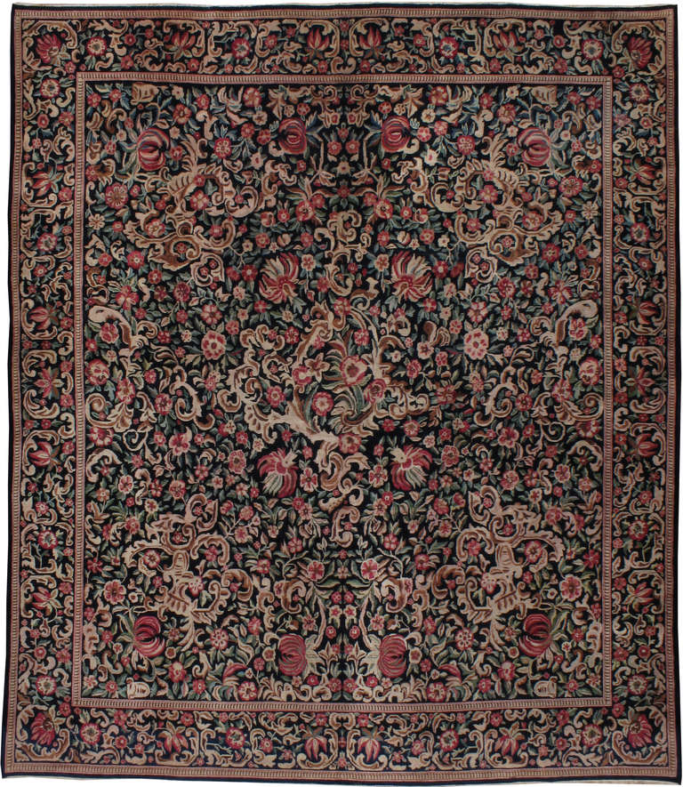 A Persian Kashan featuring a rare black field with mint and rose flower sprays, reminiscent of Karabagh rugs of the Caucus.