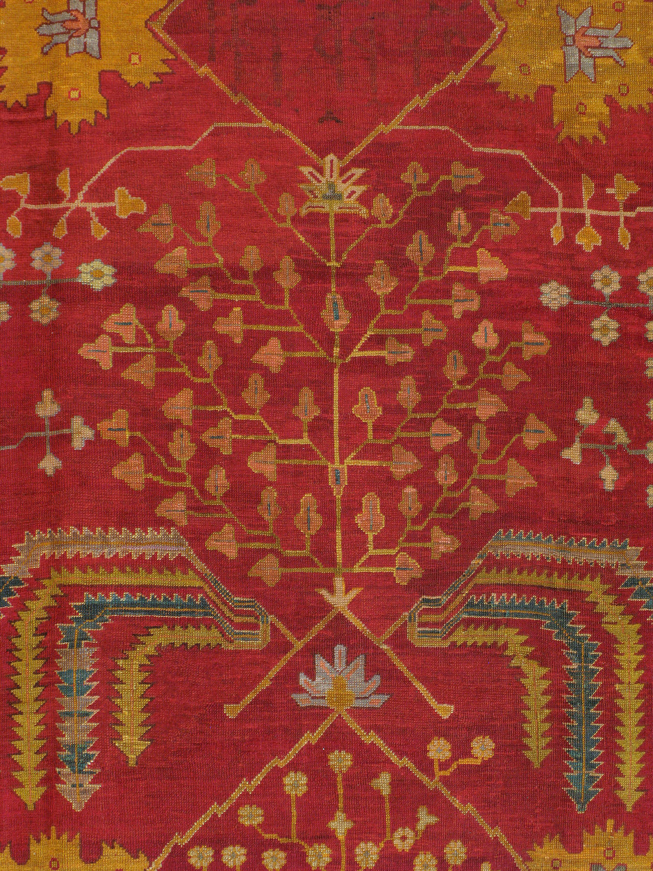 An antique Turkish Oushak carpet from the first quarter of the 20th century. A goldenrod border encompasses a crimson red field.