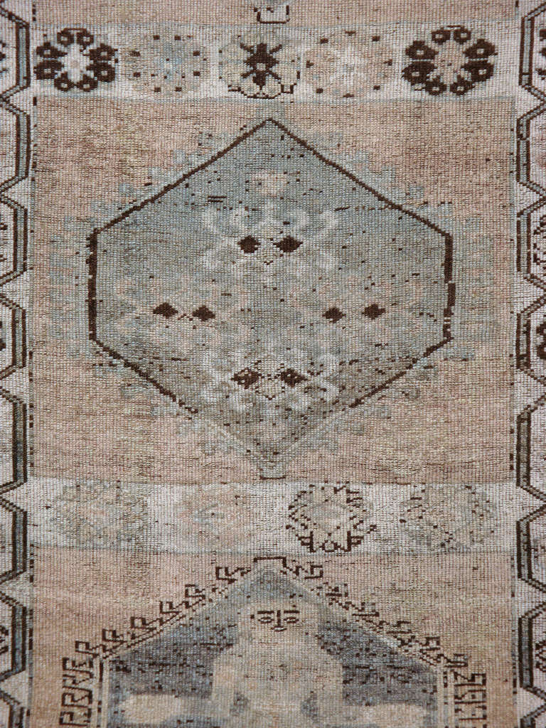 An early second quarter 20th century Persian Bakhtiari carpet with an allover medallion pattern featuring pictorial designs of women.