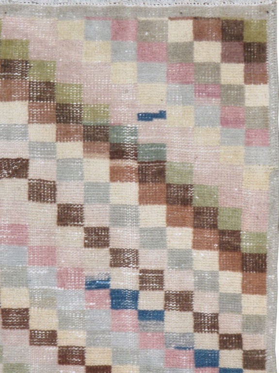 Un anatolio turco de principios del siglo XX.  Alfombra anatolia vintage con diseño de damero y textura desgastada.