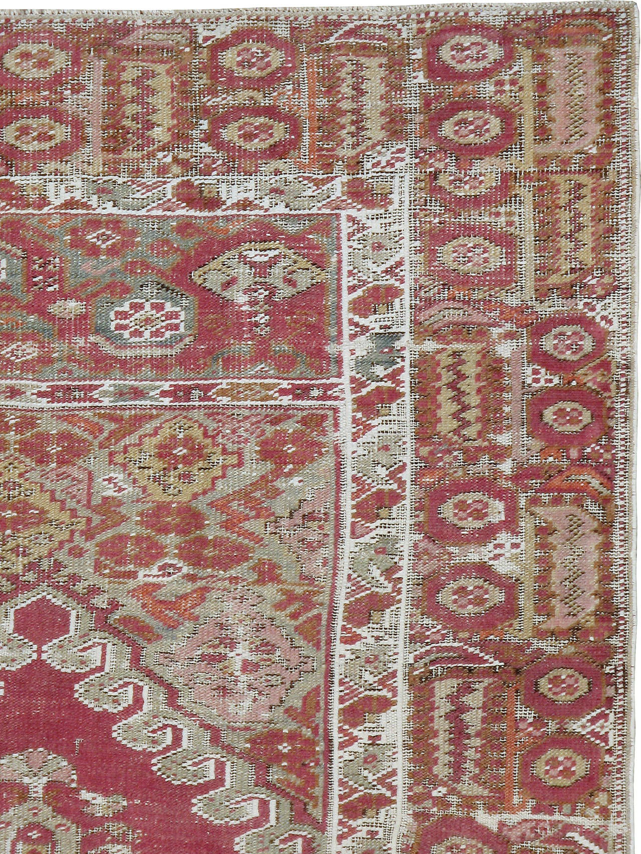 An early 20th century Turkish Ghourdes carpet. This antique Ghourdes rug offers a fire brick central field of leafy palmettes and flowers, encased by a geometric border.