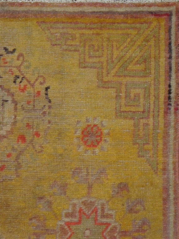 C'est un Khotan classique du début du 20ème siècle du Turkestan oriental.  	Les tapis et moquettes anciens de Khotan étaient produits dans la ville oasis du Turkestan oriental, qui fait aujourd'hui partie de la région du Xinjiang, dans l'ouest de la