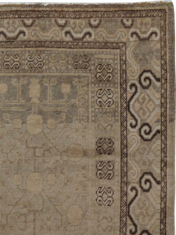 Tapis Khotan classique du début du XXe siècle du Turkestan oriental, avec des grenades sur un fond de blé.  
Les tapis et moquettes anciens de Khotan étaient produits dans la ville oasis du Turkestan oriental, qui fait aujourd'hui partie de la