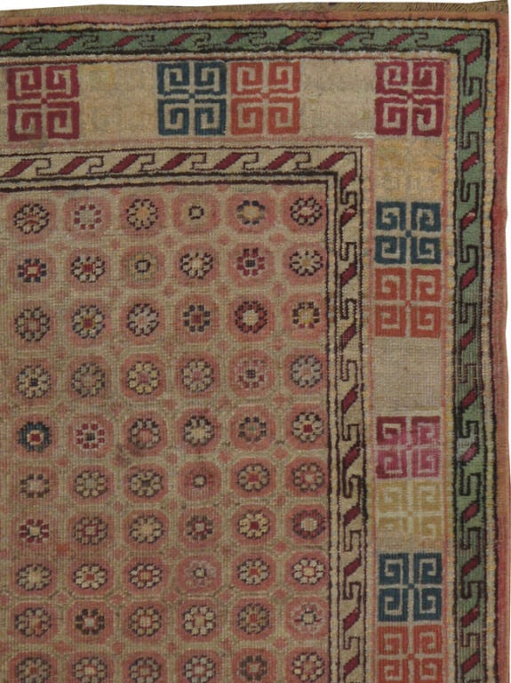 A Classic early 20th century Indian Agra, daisy style flowers set on a beige field, encased by angular hook ornament style border, inspired by Khotan weaving's of East Turkestan.