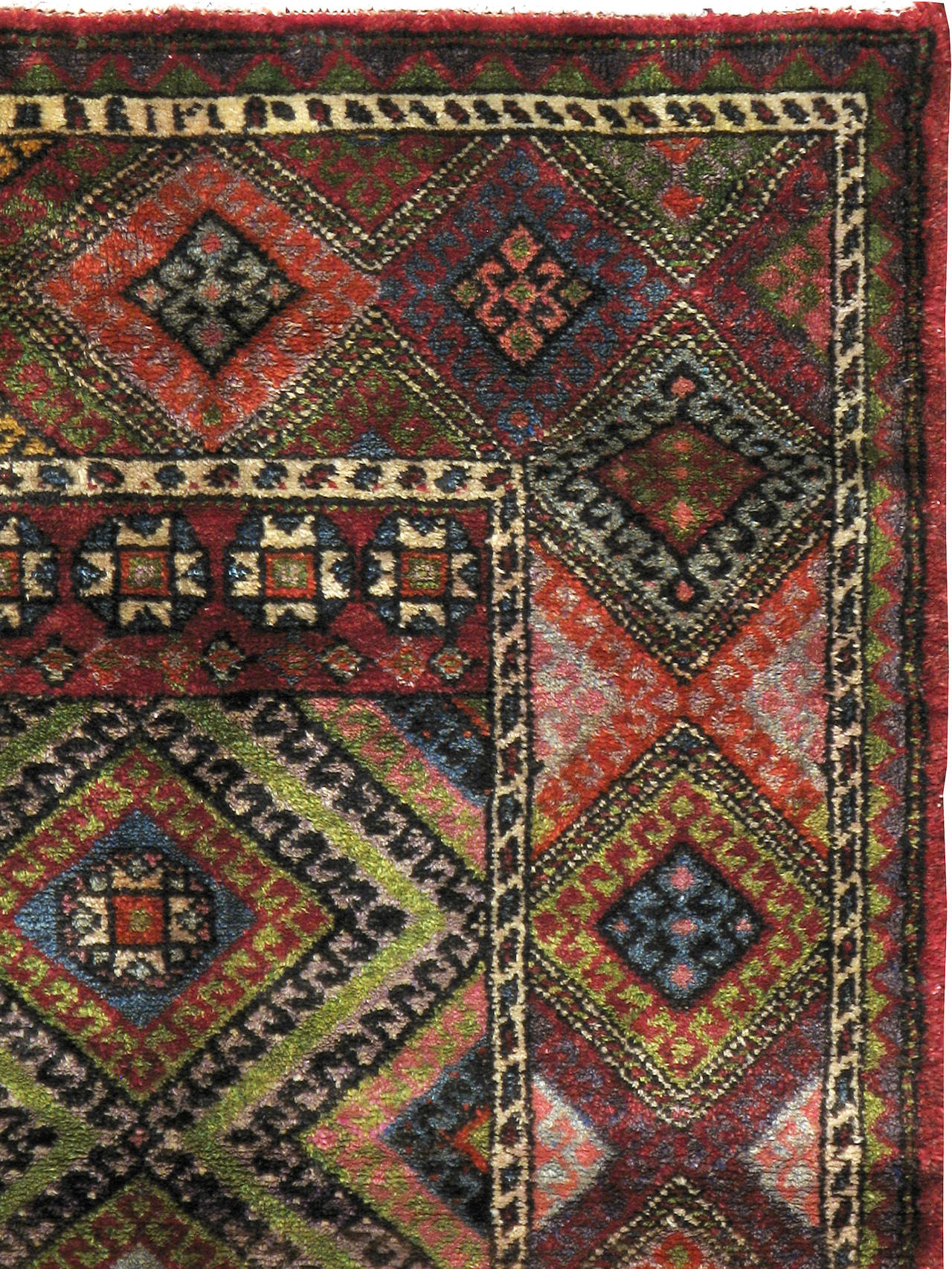 A Mid-Century vintage Anatolian carpet composed of geometric motifs in vibrant hues.