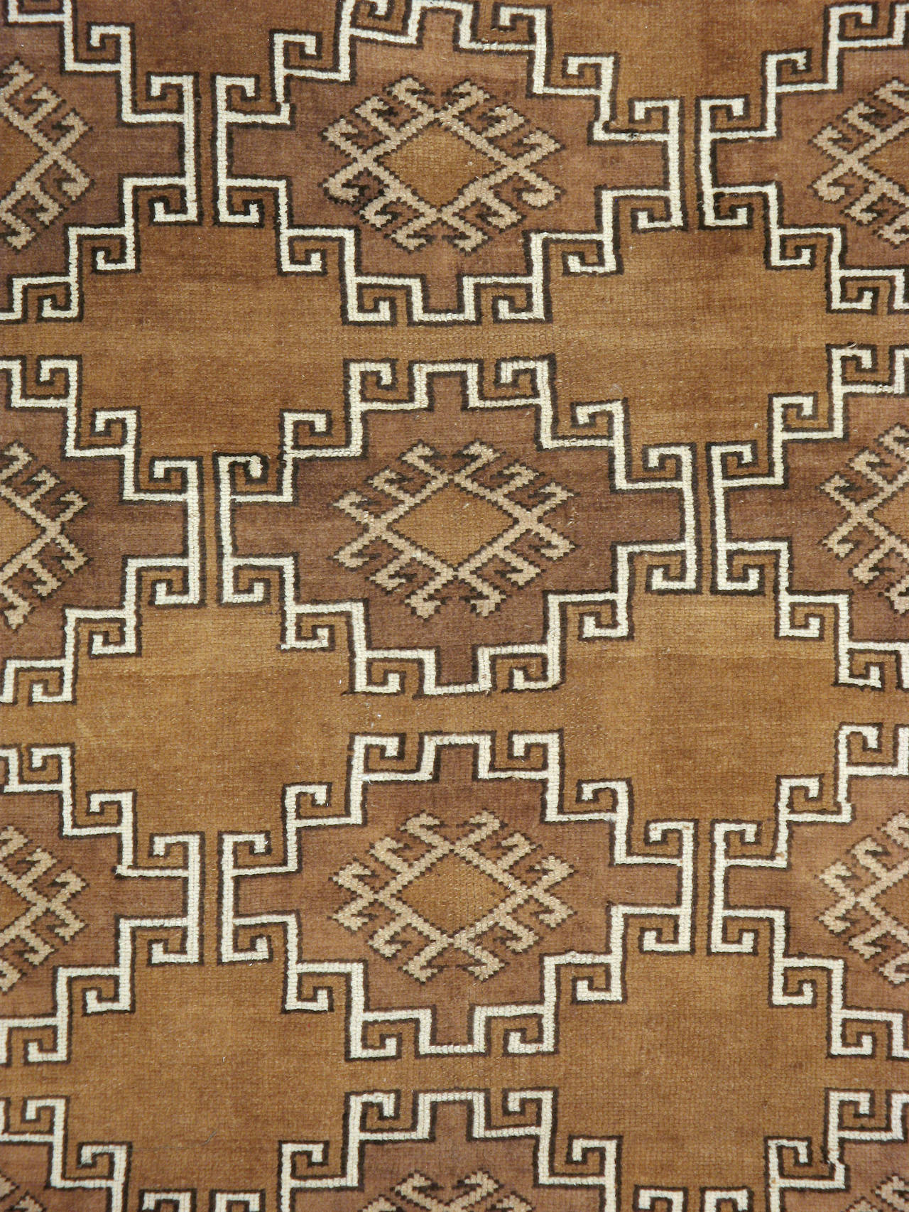 A vintage Anatolian rug from the second quarter of the 20th century with an all-over geometric pattern outlined in ivory over a minimalistic terracotta field.