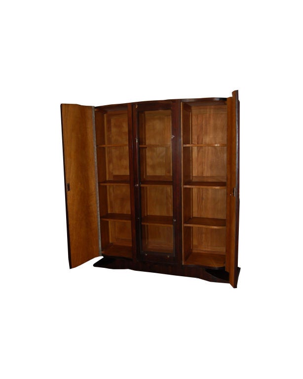French Art Deco armoire in rosewood rio with four shelves behind door in middle and four shelves behind each door on both sides. Original Art Deco nickle plated hardware.
