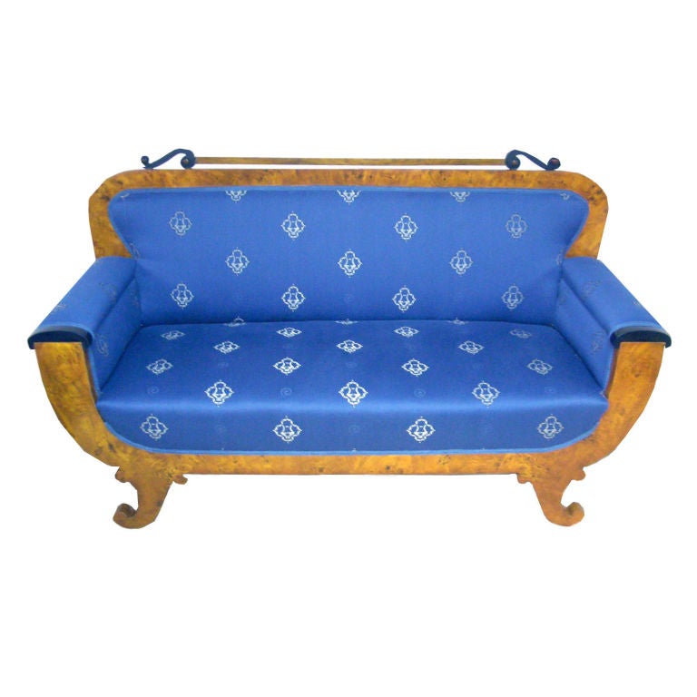 Biedermeier loveseat in walnut, rootwood and ebony with medium blue upholstery and a silver floral pattern.