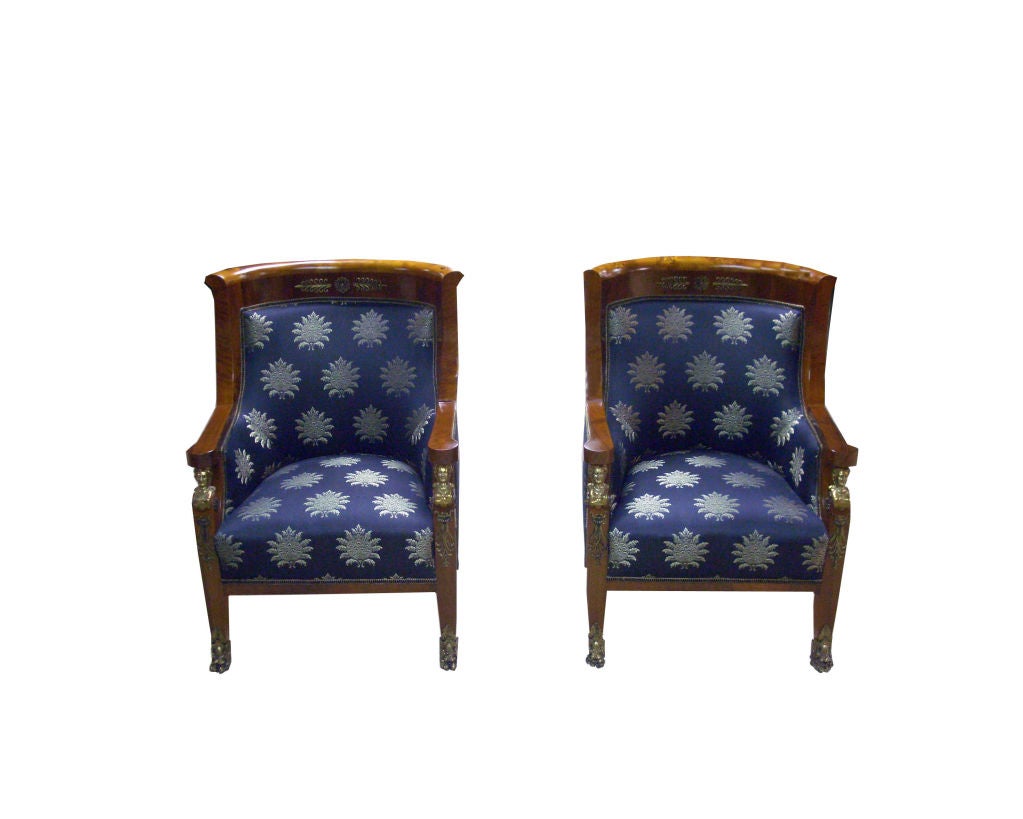 Empire loveseat in walnut and rootwood with brass fittings. Navy blue upholstery with silver floral pattern. Part of a suite with chairs E22-1.