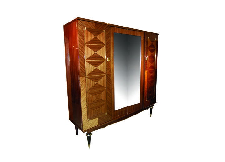 French Art Deco Armoire in macassar ebony with 2 center mirrored doors and 2 outer doors with marquetry. Interior drawers and shelves.