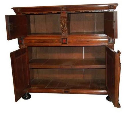 Carved oak and ebony cupboard with tortoiseshell inlay, walnut and rosewood parquetry. Doors interposed with masks and brass rings. The sides inlaid with geometric motifs.