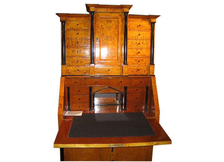 Biedermeier Revival Secretaire made of  blond burl with ebonized columns.  Upper section with exterior drawers and cubby hole.  Lower section with fall front writing surface and interior drawers.