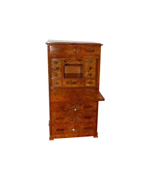 Biedermeier secretaire made of walnut, rootwood and ebonized wood. It has a fall front writing surface with interior drawers and a cubby hole. Lower section with exterior drawers.
