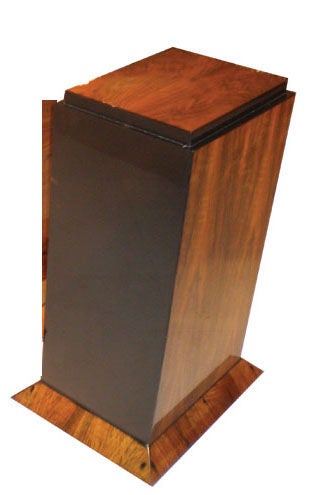 A single walnut burl pedestal with black lacquered back.