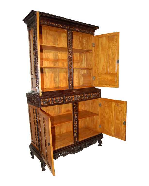 Satinwood and ebony rectangular shaped cabinet on cabinet. Upper section with a scalloped and beach molded cornice above a carved scroll frieze with panelled doors. Lower section with three frieze drawers above panelled doors and apron with carved