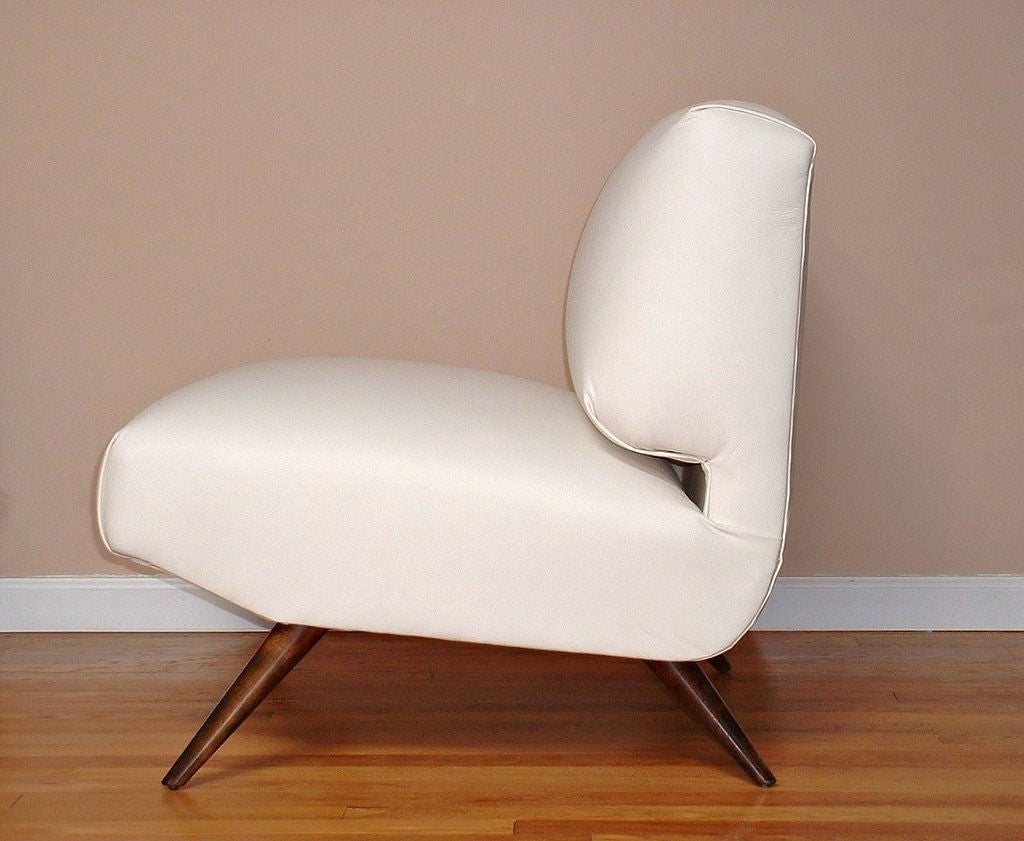 1950s gutter-back slipper chair with splayed, solid walnut legs finished with an espresso stain and newly reupholstered in Kravet ivory leather. Sleek and comfortable low-profile chair with great geometry.