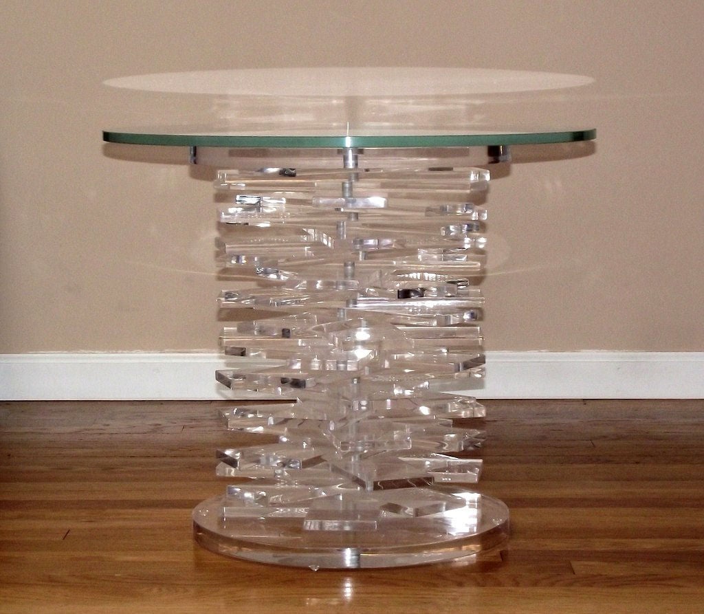 An occasional table consisting of stacked, rectangular lucite blocks between a circular lucite base and capital and finished with a round glass top. With a simple adjustment of the nut beneath the base, you may change the configuration of the blocks
