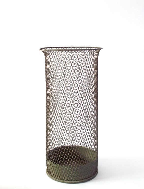 An unusually tall, mesh sheet metal wastepaper basket or trash can with an enclosed bottom, a flared rim and rolled metal lip and base by Nemco (Northwestern Expanded Metal Company of Chicago), manufactured by the F.H. Lawson Company. Retains its