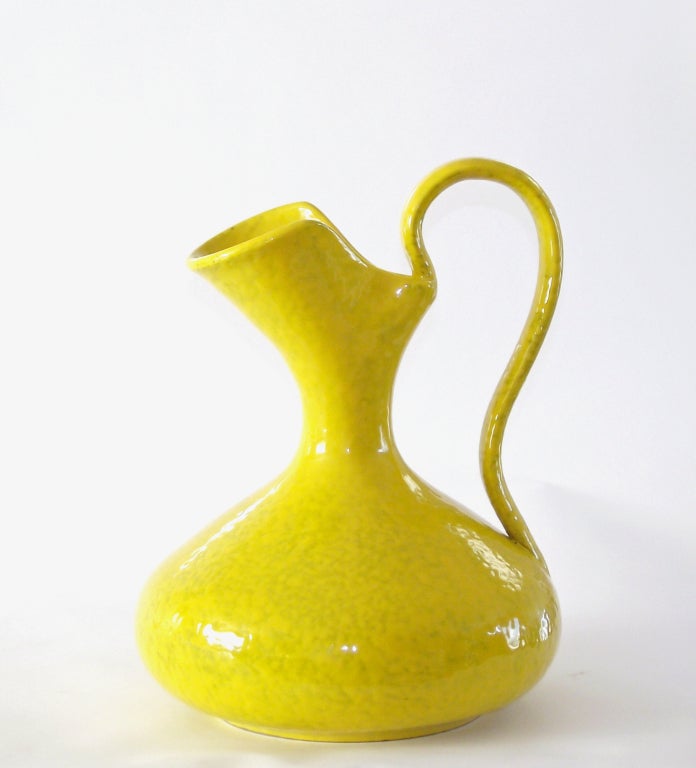 A large-scale ceramic ewer/vase in a lively shade of citrus-yellow and finished with a gloss glaze. The dimpled and faintly mottled surface does indeed resemble lemon rind. Made in Italy, imported by Rosenthal Netter (signed to underside). Quite
