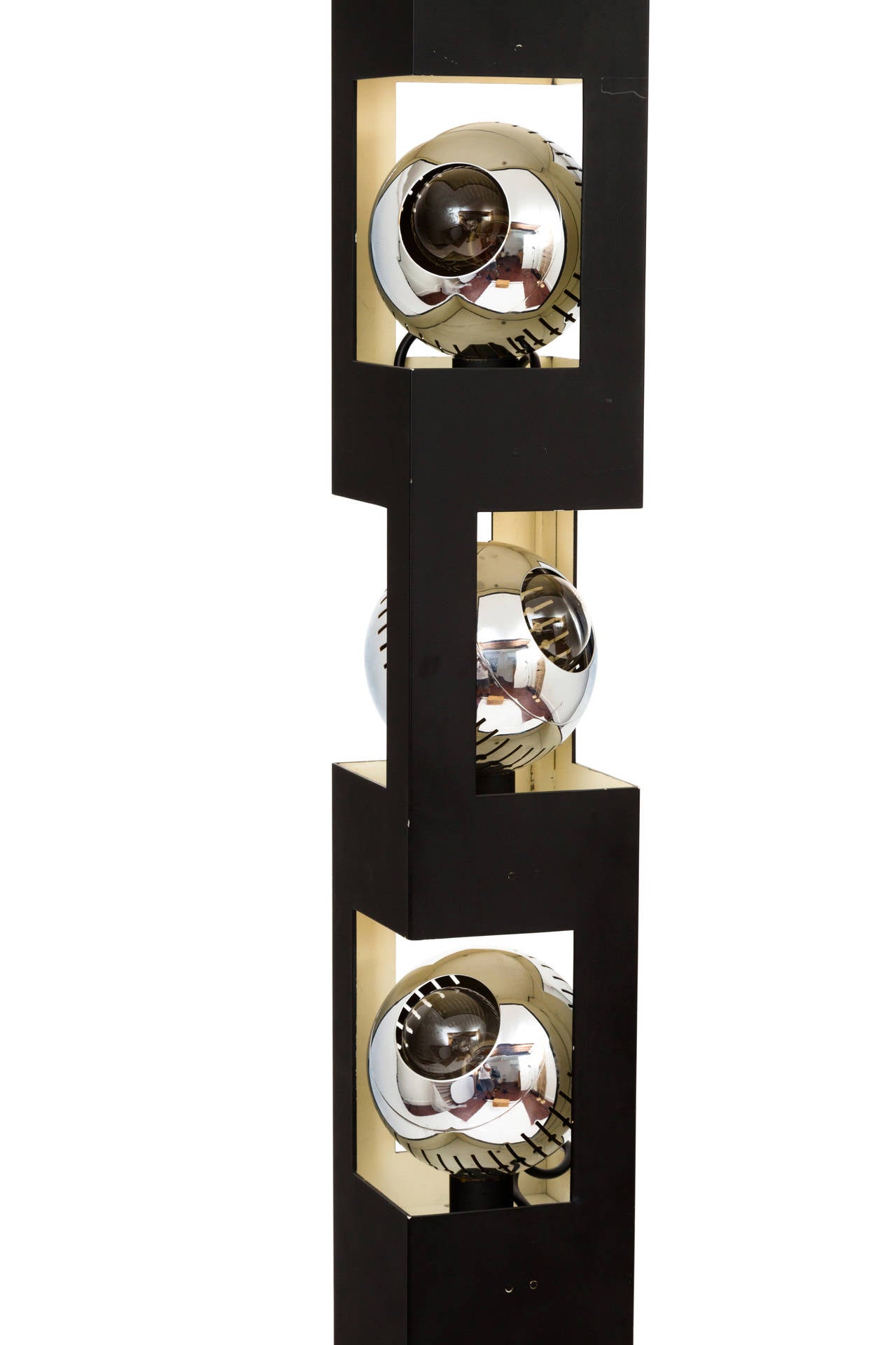 A rare floor lamp designed by Angelo Lelli and produced by Arredoluce, consisting of a square, columnar upright in matte black-enameled steel with three cut-away sections, each housing a magnetic, fully adjustable 