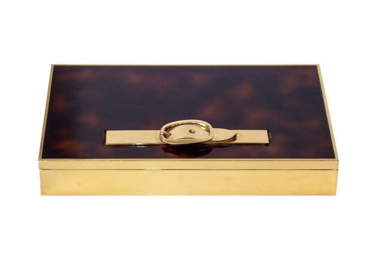 Hermes decorative box in gold plate over solid brass with a richly lacquered top in a faux tortoise shell pattern and adorned with a belt and buckle handle. The interior is wood lined with  three equally-proportioned compartments, originally