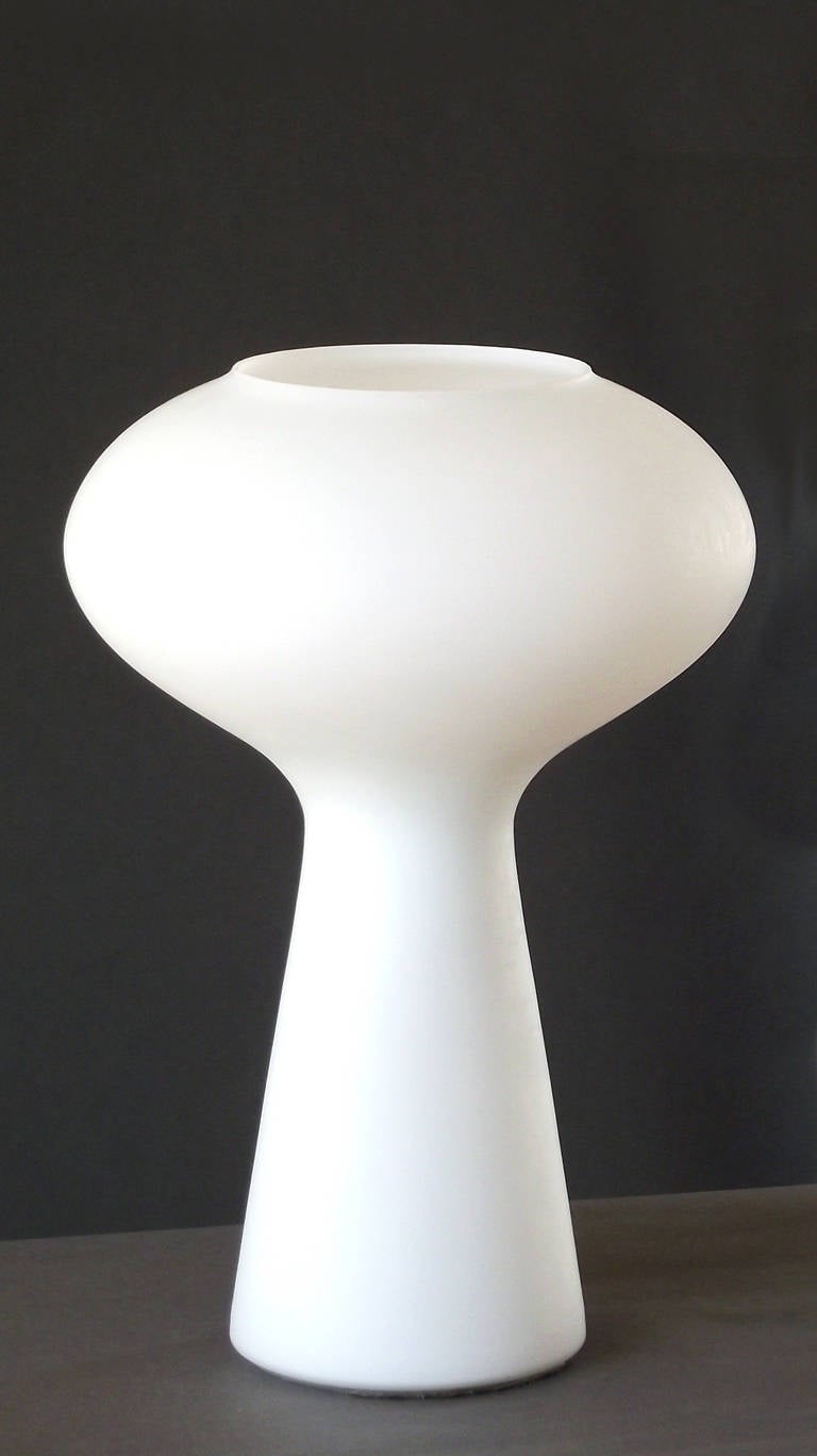 A frosted, white cased glass (single piece) table or desk lamp in a mushroom cloud form, designed in 1954 by Lisa Johansson-Pape. A design classic that provides beautifully-diffused illumination, documented in: 1000 Lights, Charlotte & Peter