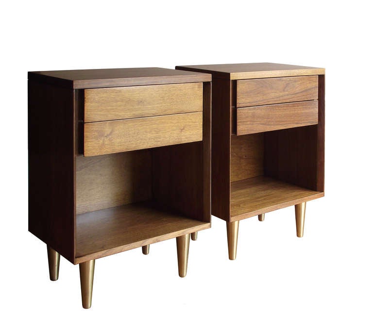 A pair of classically modern nightstands in an open rectangular form with a pair of drawers at top and supported by conical, brass-plated legs. Note the chamfered edge detail to the front sides (image 3). Lovely grain pattern throughout. Retailed
