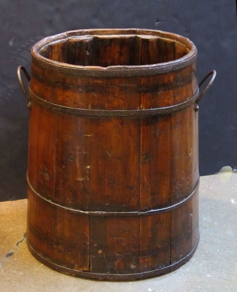 A large Bavarian coopered barrel of iron-bound wood.
With handles on sides and hooks on back for hanging.