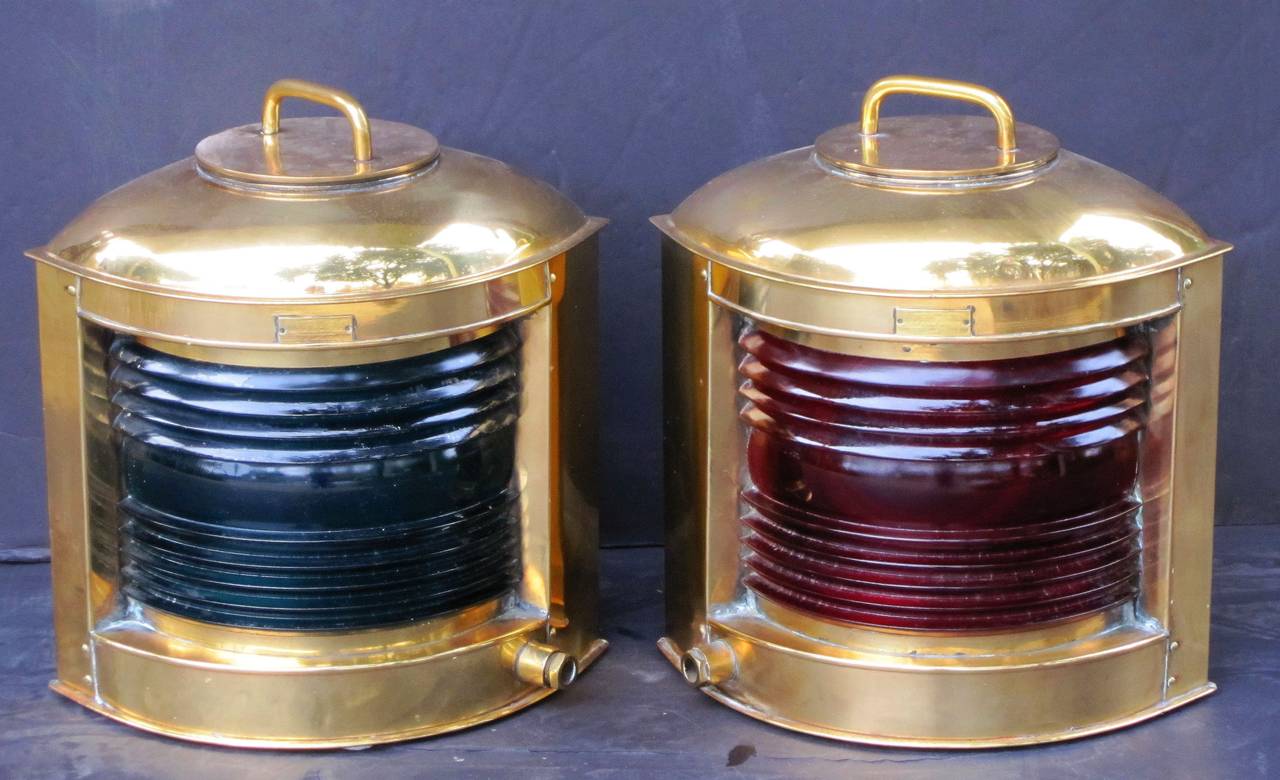 A handsome pair of English marine or ship's lights (lanterns) of brass with colored glass inserts of green (starboard) and red (port).

The tops featuring removable brass handles and nameplates to the bowed faces.The backs with heavy brass